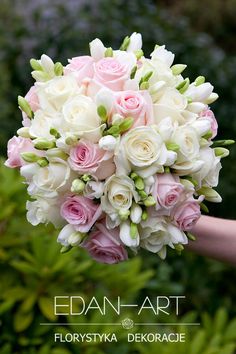 a bridal bouquet with pink and white flowers is held by someone's hand