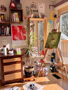 an artist's studio with easel, potted plant and other art supplies