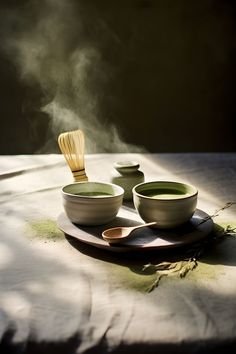 three bowls and spoons on a table with steam rising from them