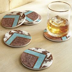 Exclusive Item - Backed with cork, these stone coasters not only protect your surfaces, but also add a touch of western charm to your drinkware presentation. Made in the USA. 4"Dia. each. Western Coasters, Cowhide Coasters, Coaster Projects, Western Crafts, Black Forest Decor, Art Coasters, Home Themes, Rustic Cabin Decor, Kitchen Dinnerware