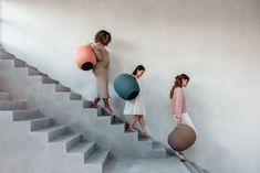 three women are walking up the stairs with large balls