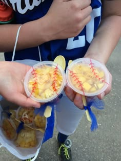 two people holding plastic containers filled with food