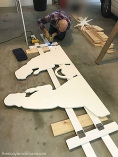 a man working on a large wooden cutout