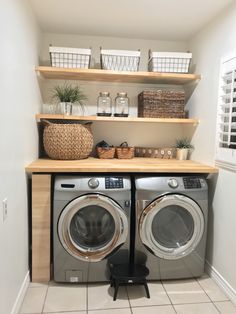 a washer and dryer in a small room with shelves on the wall above them