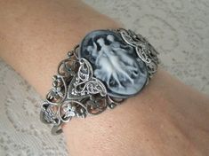 Triple Goddess Cuff Bracelet This beautiful silver plated filigree cuff bracelet has silver plated filigree accents and a triple goddess cameo. Adjustable. Silver Metal Cameo Jewelry, Victorian Bangle As Gift, Silver Cameo Bracelet For Gifts, Victorian Cuff Bracelet For Wedding, Elegant Silver Bracelet With Cameo, Silver Gothic Cameo Jewelry, Silver Gothic Bangle, Vintage Silver Cameo Bracelet, Jewelry Magic