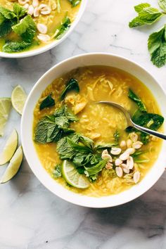 two bowls filled with soup and garnished with limes