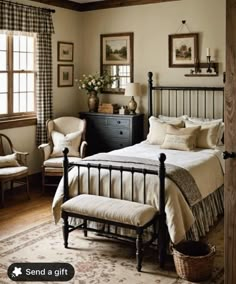 a bed room with a neatly made bed next to two chairs and a table in front of a window