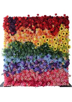 a multicolored flower wall with flowers arranged in the shape of a rainbow flag