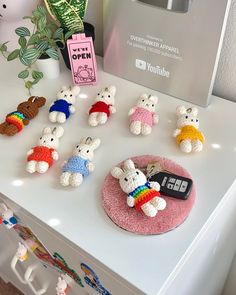 small crocheted stuffed animals are sitting on a table next to a remote control