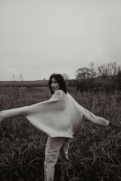 a woman standing in the middle of a field