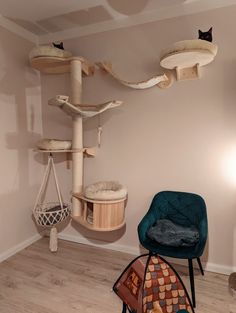 a cat tree in the corner of a room with two chairs and a hammock