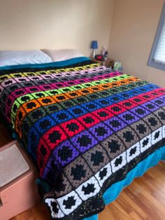 a bed with a colorful blanket on top of it