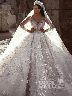 a woman in a wedding dress standing next to a stone wall