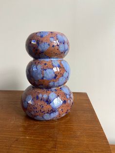 three stacked rocks sitting on top of a wooden table