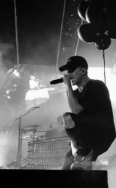 a black and white photo of a man holding a microphone in front of his face