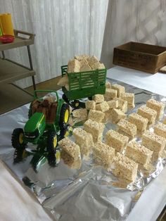 there is a cake made to look like a tractor and some blocks of rice on the table