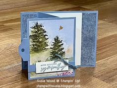 a close up of a card on a wooden table with a tree in the background