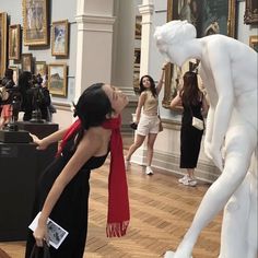 a woman looking at a statue in a museum