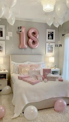 a bedroom decorated in pink and white with balloons