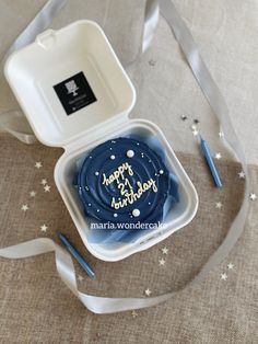 a blue birthday cake in a white container