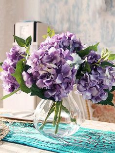 a vase filled with purple flowers on top of a table