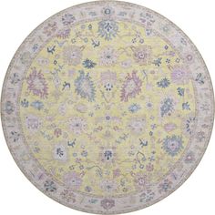 a yellow and blue rug with floral designs on the center, in an oval shape