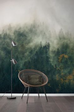 a chair and lamp in front of a forest wall mural