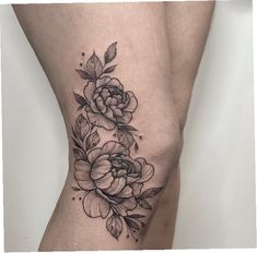 a woman's thigh with flowers on it and leaves around the thighs, in black ink