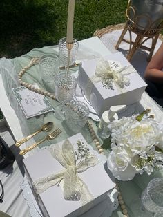 the table is set with two boxes and flowers