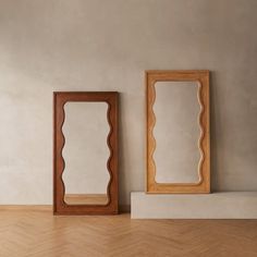 two mirrors sitting on top of a wooden floor next to each other