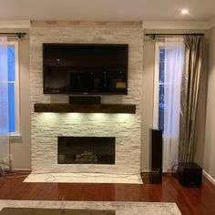 an empty living room with a fireplace and flat screen tv