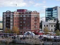 the buildings are next to each other on the water's edge with snow covered mountains in the background