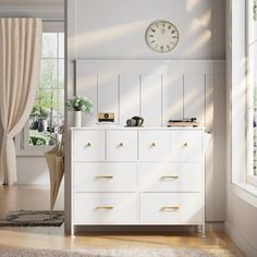 a white dresser sitting next to a window in a living room with a clock on the wall