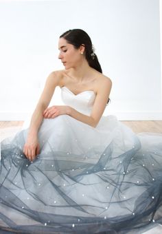 a woman in a white dress sitting on the floor