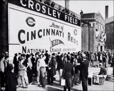 an old black and white photo of people standing in front of a building with a sign