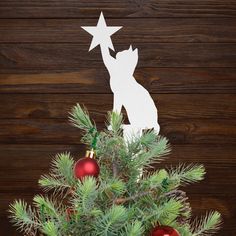 a christmas tree decorated with ornaments and paper cutout dog on it's head