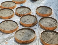 there are many sand bowls sitting on the table with plastic wrap around them and one is empty