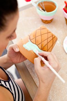 a woman is painting an ice cream cone