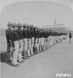 a group of men standing next to each other in front of a line of people