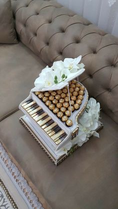 a couch with a tray full of snacks on top of it and flowers in the middle