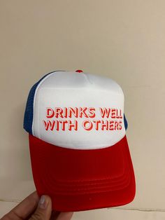 Head out in style with the Drinks Well With Others trucker hat! This one-of-a-kind, tri-colored design looks and feels awesome, so you can make a statement without saying a word. Plus, the adjustable snapback ensures everyone can enjoy this fashionable accessory. Get ready to turn heads! Funny Trucker Hat, One Size Fits Most, Funny Trucker Hat One Size, Funny One Size Fits Most Trucker Cap, Funny Trucker Hat With Letter Print, Funny Letter Print Trucker Hat, Funny Snapback Trucker Hat, Funny Trucker Hat With Curved Brim, Funny Letter Print Trucker Hat For Streetwear, Funny Snapback Baseball Cap