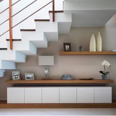 a living room filled with furniture under a stair case