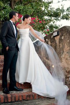 the bride and groom are standing on some steps