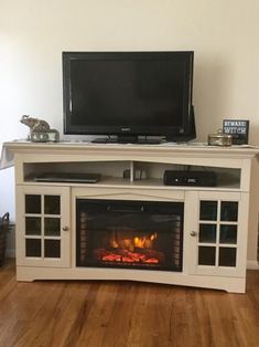 an entertainment center with a fire place and television on it's stand in front of the fireplace