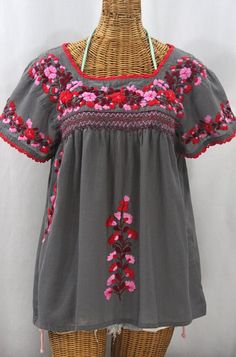 * Ornate hand embroidery and smocking with hand crocheted trim on the neck and open sleeve hems, available here in MEDIUM GREY with RED MIX embroidery. * Light, gauzy and semi-sheer 100% cotton throughout; wear it billowy and flowing in the bohemian style, or belted for a more fitted look. * Dyed, distressed  and embroidered by hand for an authentic, retro-vintage and boho-chic hippie vibe.  * Our colorful and ornate floral embroidery patterns are a faithful tribute to the traditional hippie pea Folk Style Embroidered Red Peasant Top, Red Embroidered Folk Peasant Top, Traditional Red Peasant Top With Floral Embroidery, Red Peasant Top With Floral Embroidery, Red Floral Embroidered Peasant Top, Embroidered Red Cotton Peasant Top, Red Embroidered Cotton Peasant Top, Embroidery Light, Mexican Embroidery