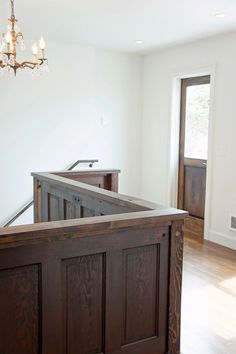 an empty room with wood floors and a chandelier