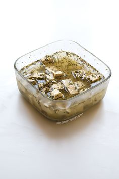 a glass dish filled with food on top of a white table