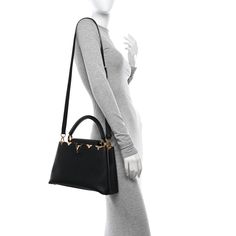 This is an authentic LOUIS VUITTON Taurillon Embellished Flower Crown Capucines PM in Black. This beautiful shoulder bag is composed of luxurious textured calfskin leather in black. The handbag features a single rolled leather reinforced top handle with stylized links, and a crossover flap that inserts behind the prominent black and gold LV. This opens to a partitioned black leather interior with a zipper pocket. Leather Interior, Authentic Louis Vuitton, Flower Crown, Black And Gold, Crossover, Top Handle, Zipper Pocket, Calf Skin, Black Leather