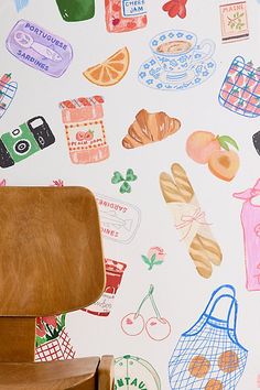 a chair sitting in front of a wall covered with food and kitchen related items on it