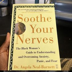 someone holding up a book about soothe your nerves